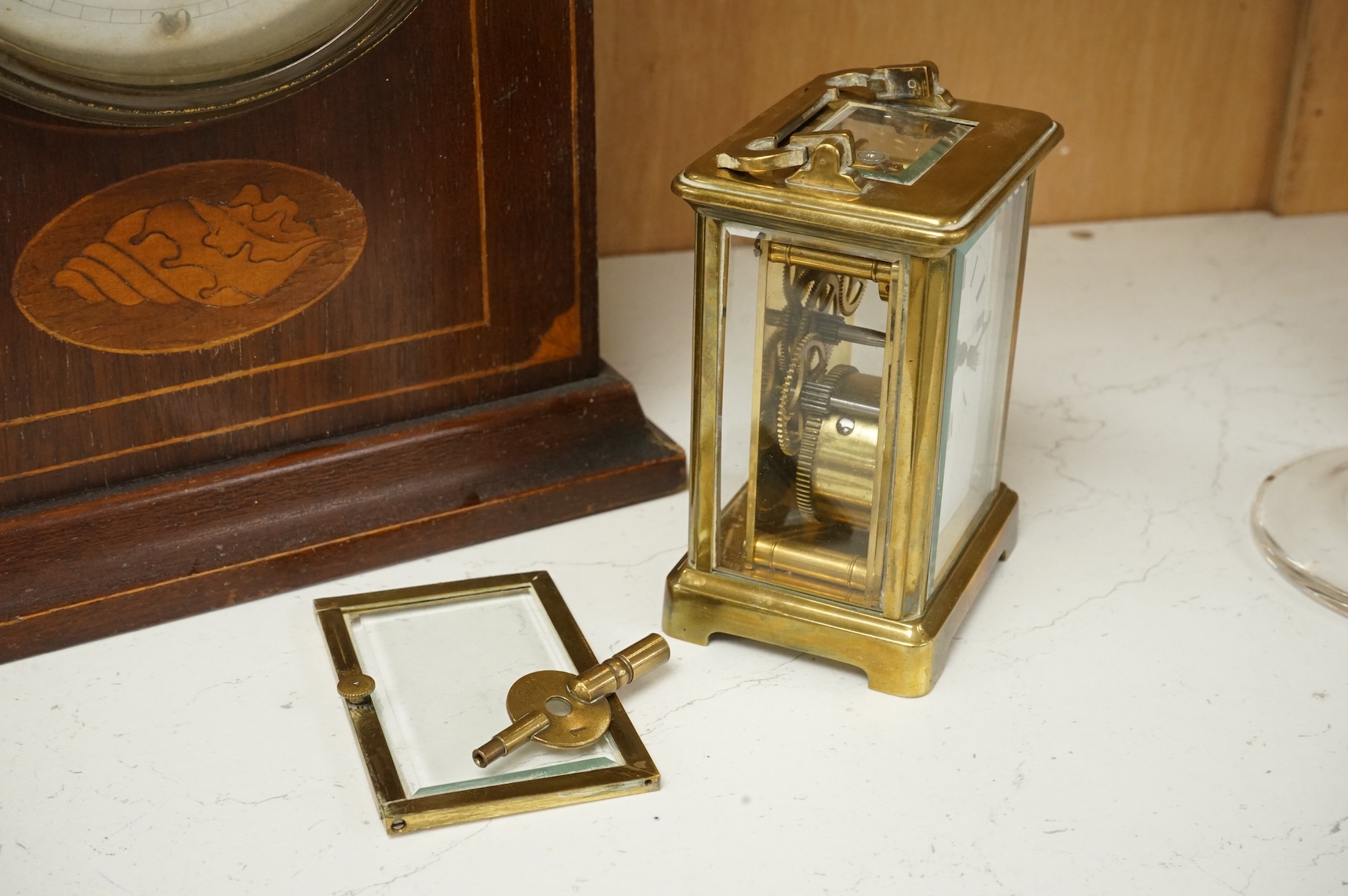 An early 20th century inlaid mantel clock with key and pendulum and a brass cased carriage timepiece, largest 32cm high
